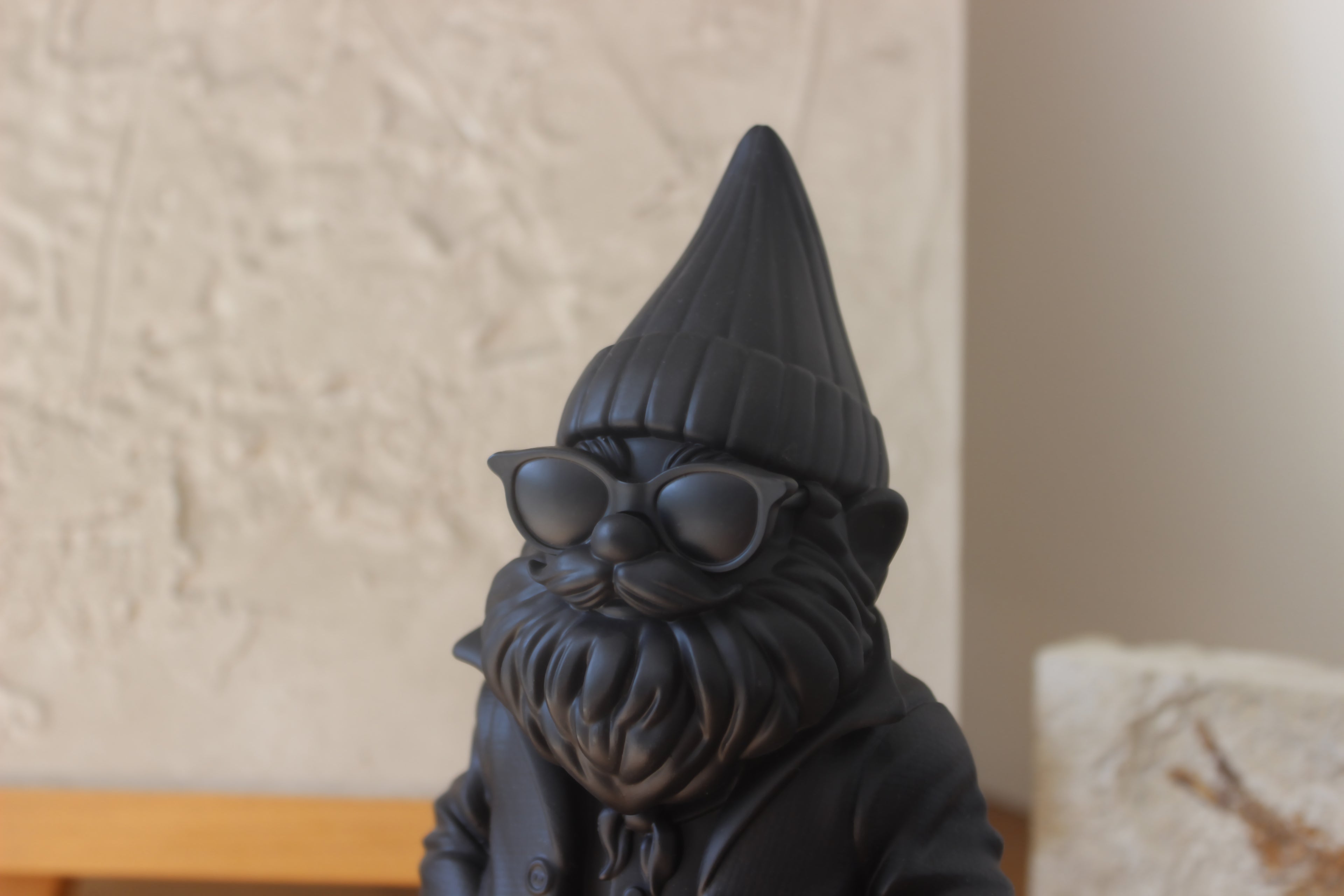 Black garden gnome with sunglasses on a neutral background